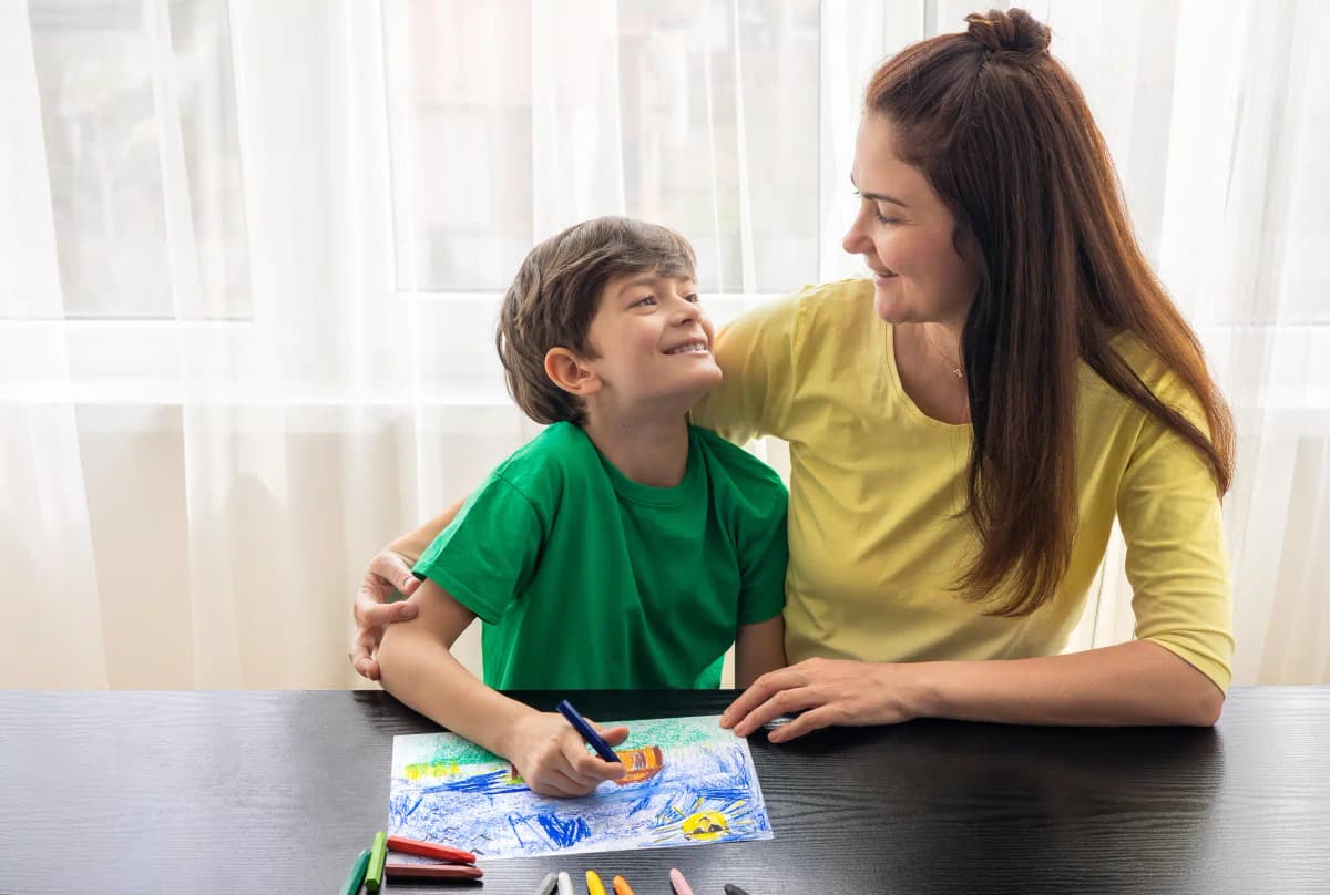 Mãe e filho com autismo desenhando juntos