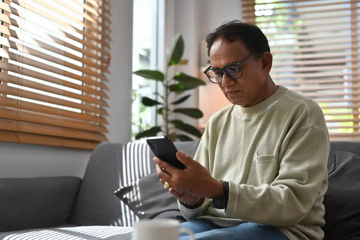homem idoso sentado olhando o celular