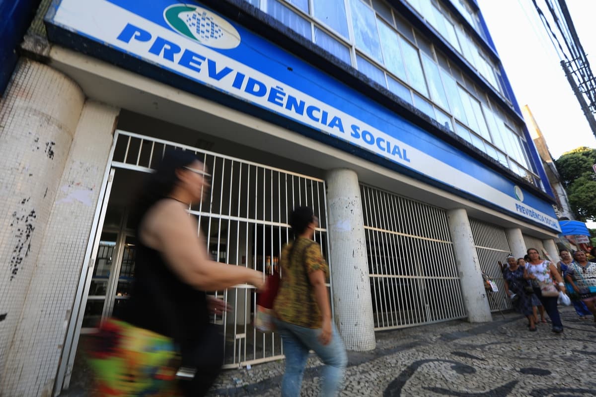 pessoas andando na frente do prédio da previdência social