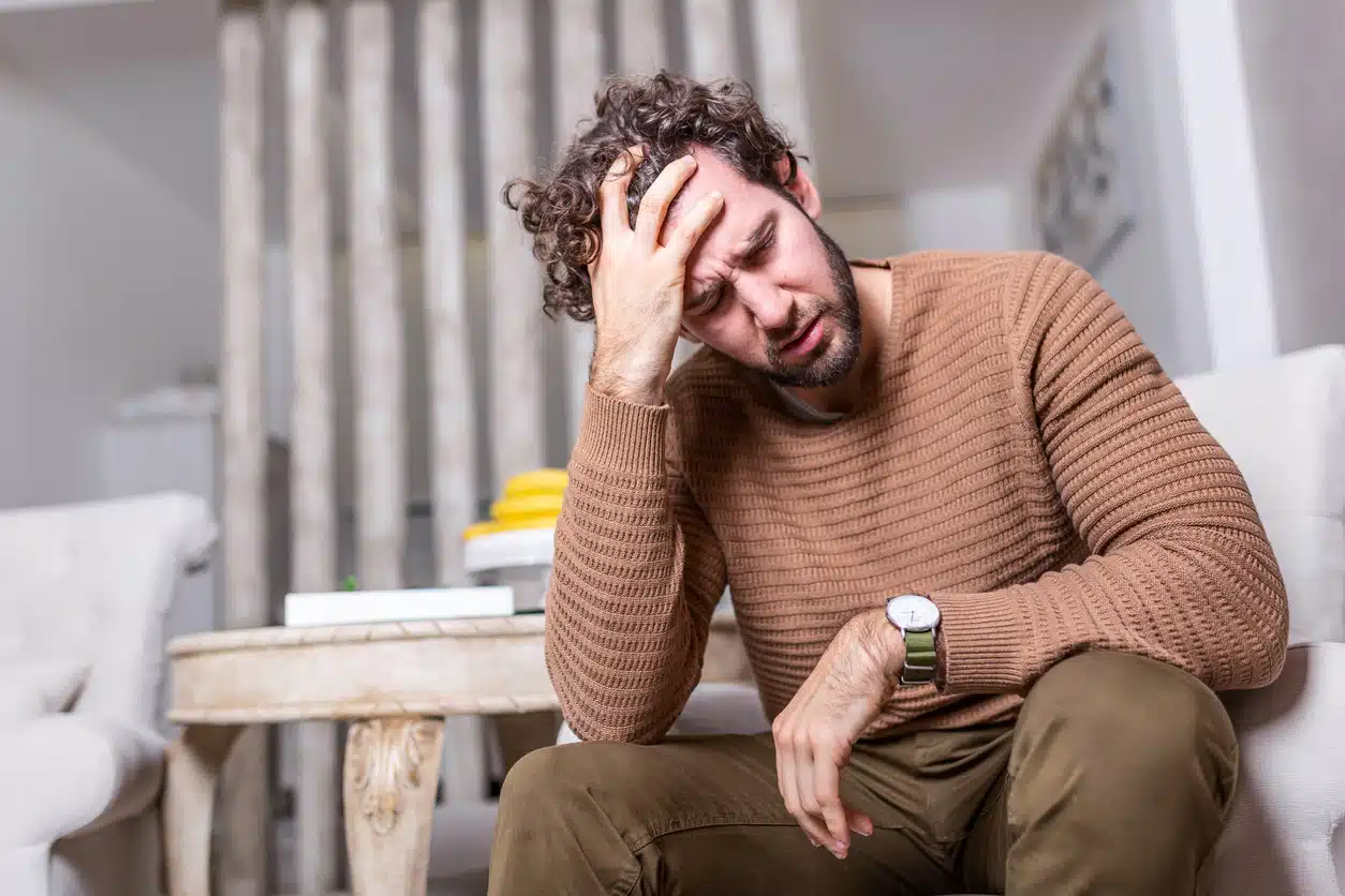Jovem frustrado que sofre de dores de cabeça crônicas diárias