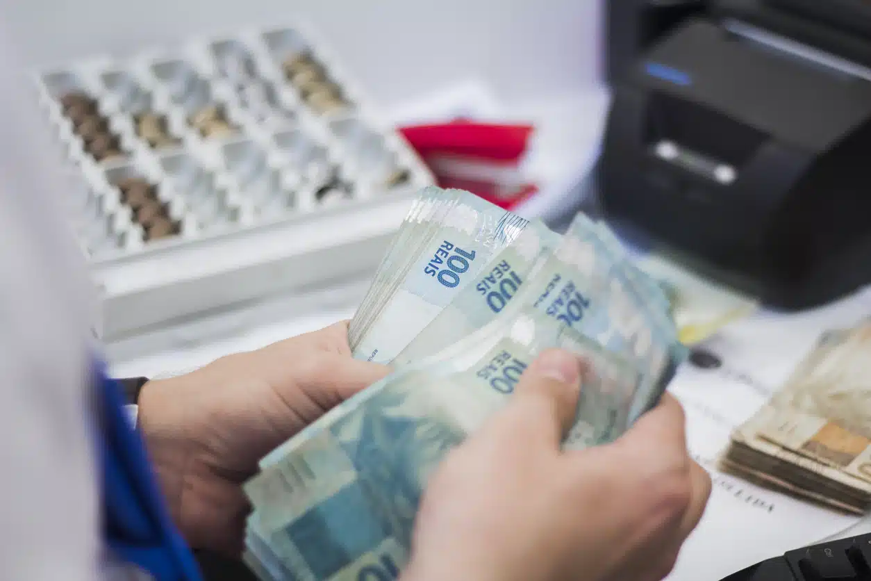 mãos contando dinheiro em destaque