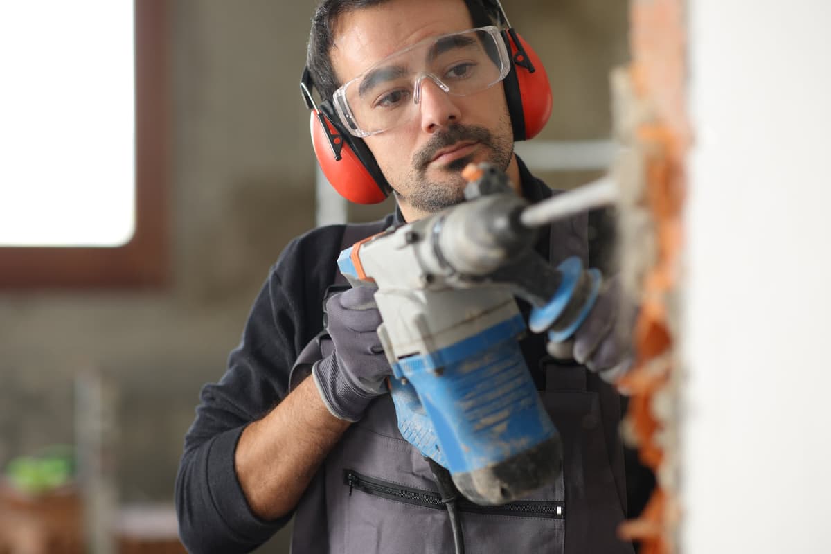 homem trabalhando com ruido usando protecao nos ouvidos