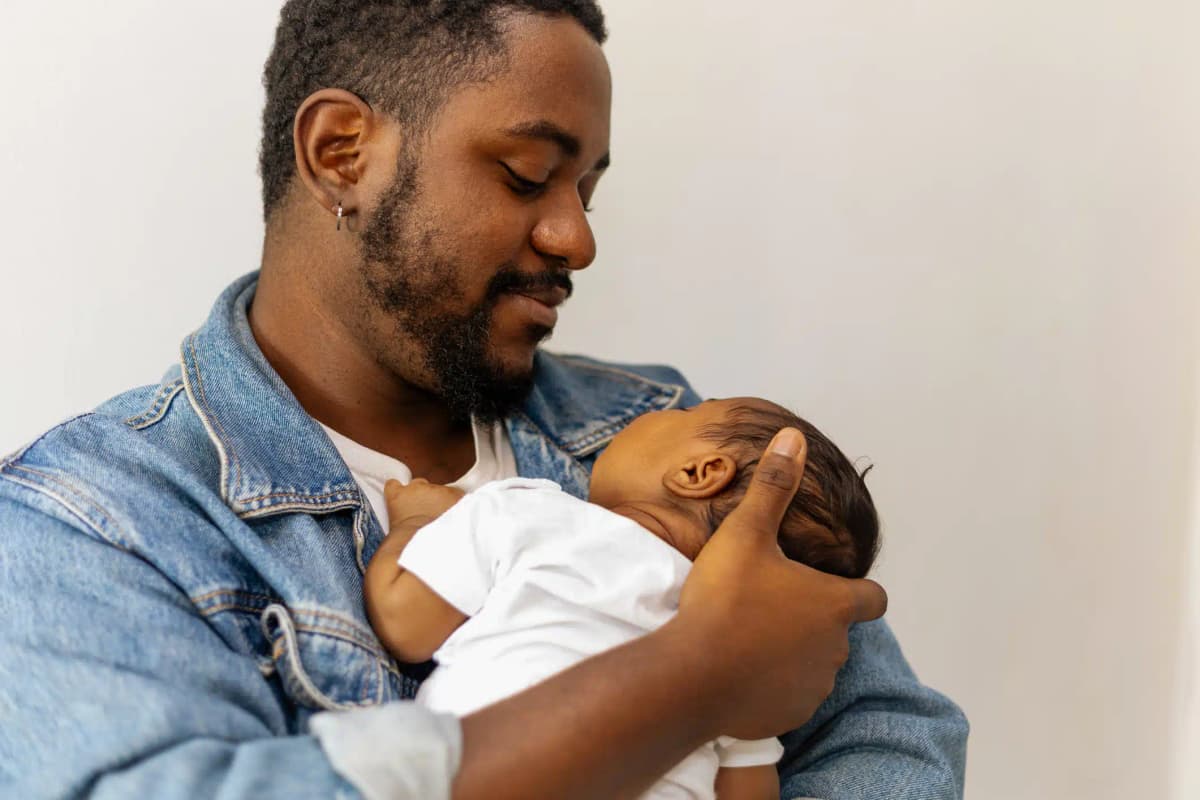 pai jovem segurando filho bebê no colo