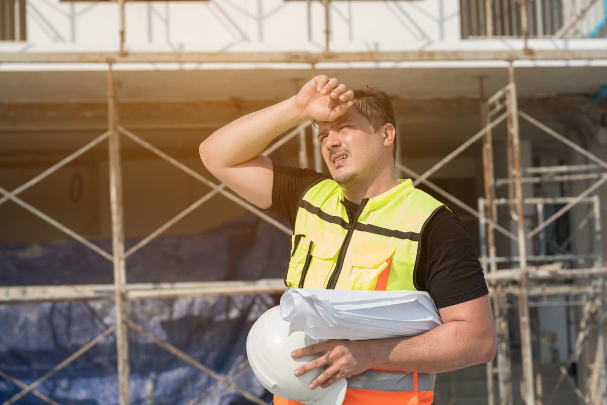 homem trabalhador exposto ao calor se protegendo do sol