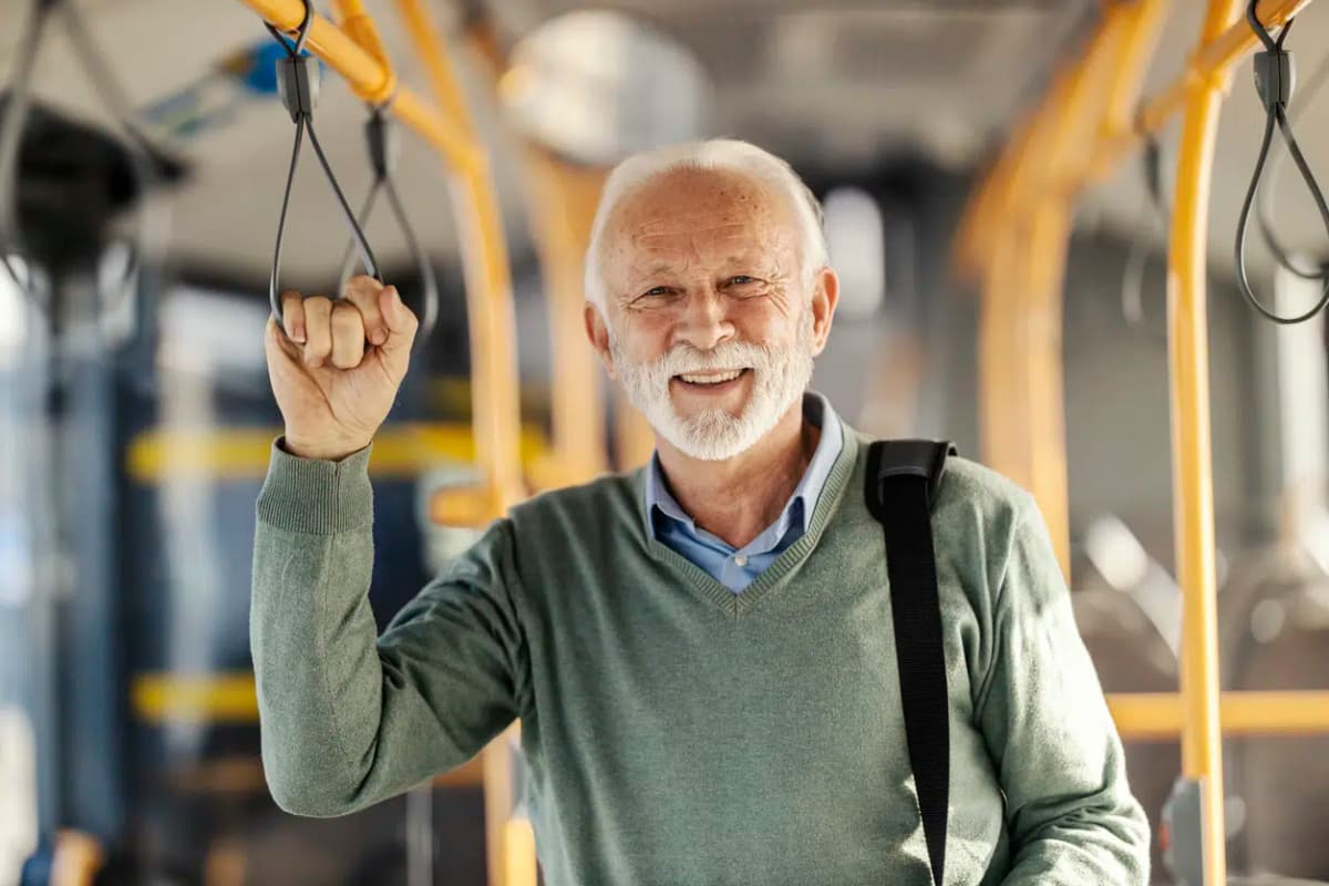 homem idoso feliz aposentado dentro de ônibus