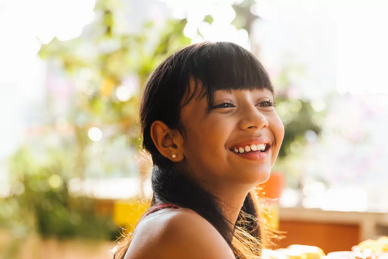 criança sorri feliz olha para horizonte